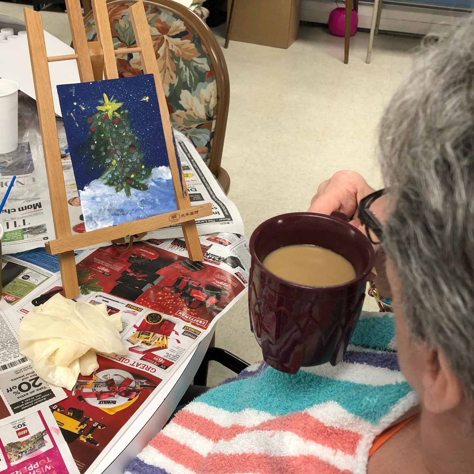 Image of woman drinking coffee and painting at Kadima at Pottstown Nursing and Rehabilitation Facility